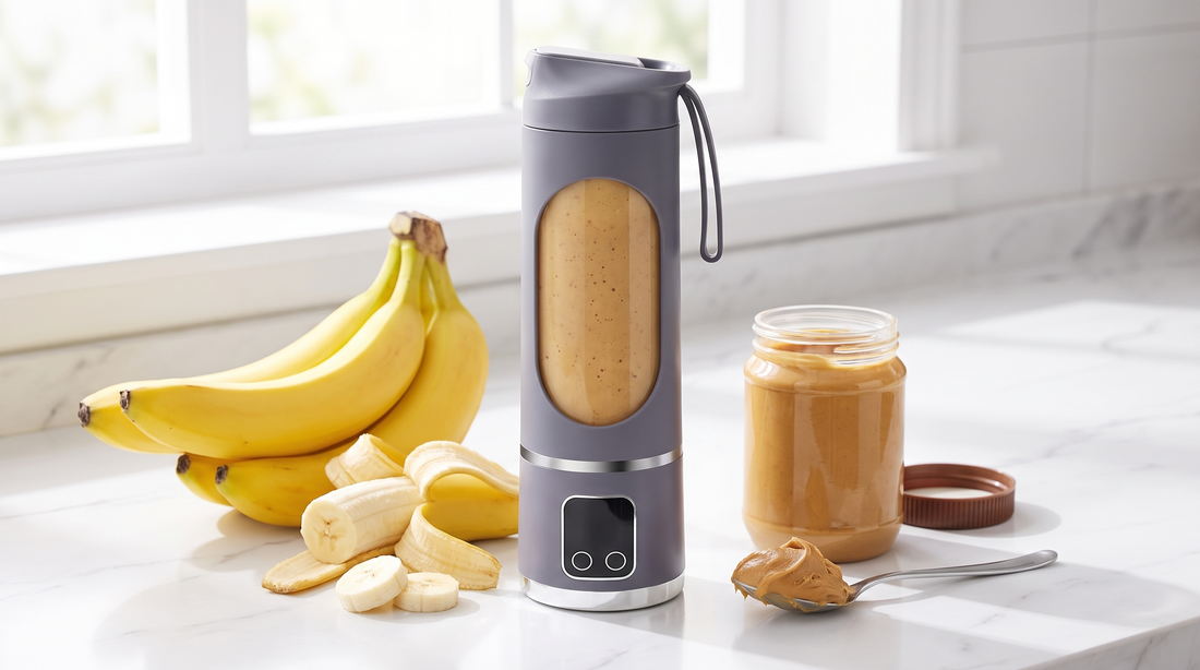 Creamy peanut butter banana smoothie in a NEWDRU portable blender bottle with ripe bananas and peanut butter on a kitchen counter